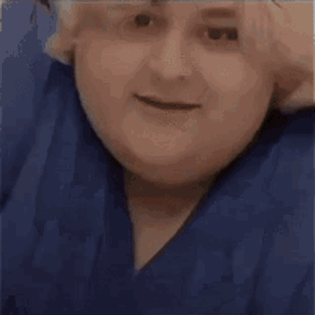 a very fat woman in a blue shirt is clapping her hands .