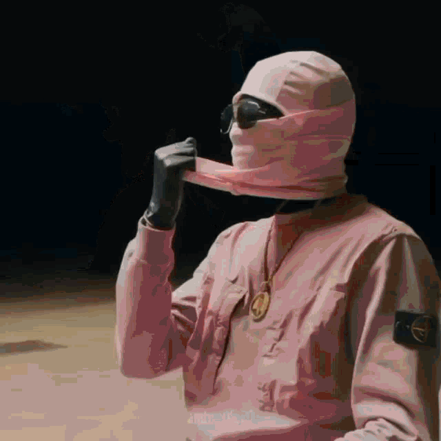 a man wearing a pink jacket and a pink mask on his head