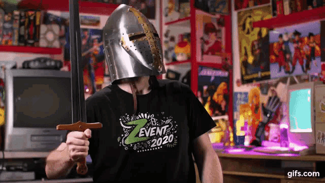 a man wearing a knight 's helmet and holding a sword is wearing a shirt that says event 2020