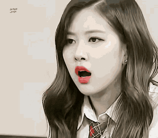 a close up of a woman 's face with her mouth open . she is wearing a school uniform and tie .