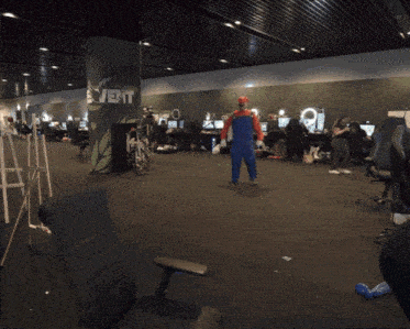 a man in a mario costume is standing in front of a pillar that says event