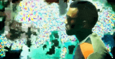 a man is standing in front of a colorful background in a blurry photo .