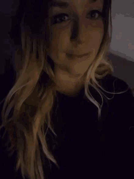 a woman is making a middle finger gesture in a dark room