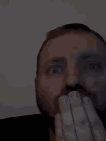 a close up of a man 's face with a black shirt on