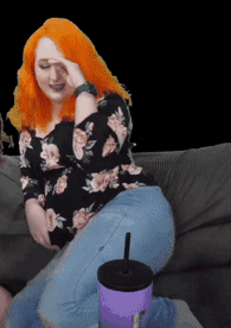 a woman with red hair is sitting on a couch