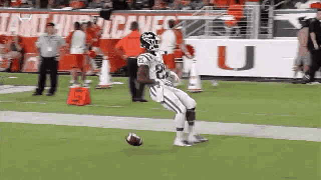 a football player is kneeling on the field with a ball .