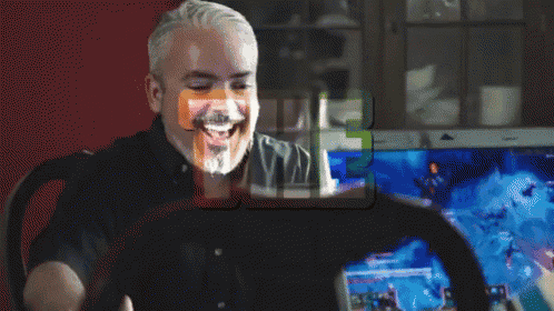 a man is laughing while looking at a laptop screen