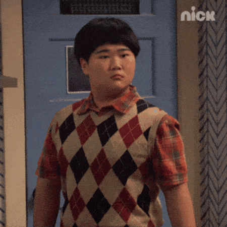 a boy in a plaid shirt is standing in front of a blue door with the word nexio written above him