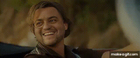 a man is smiling while sitting in a car with a woman .