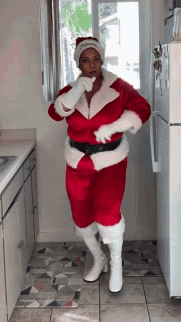 a woman in a santa costume is standing in front of a refrigerator