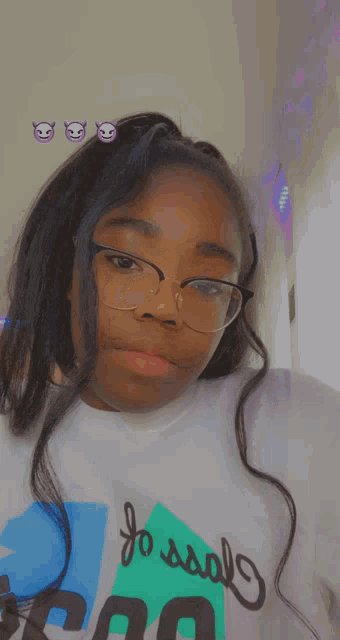 a girl wearing glasses and a shirt that says " fossils "