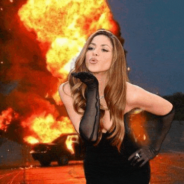 a woman is blowing a kiss in front of a car on fire .