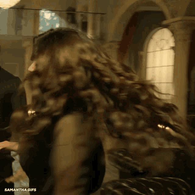 a woman with long hair is standing in front of a window with the words samantha gifs on the bottom