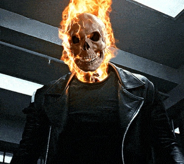 a man with a burning skull on his head is wearing a leather jacket