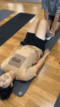 a woman in a hurley shirt is laying on a mat