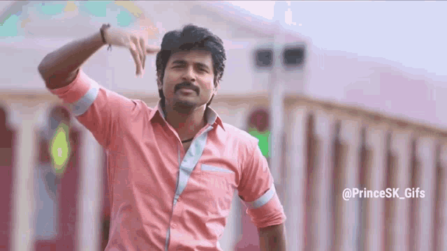 a man in a pink shirt is making a funny face
