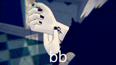 a person with black nails has a tattoo on their wrist