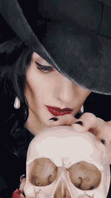 a woman in a black hat holds a white skull