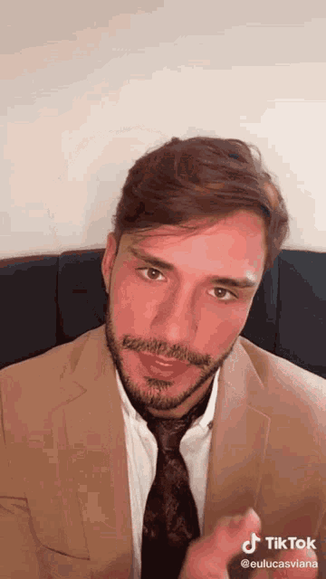 a man wearing a suit and tie has a tiktok icon on his face