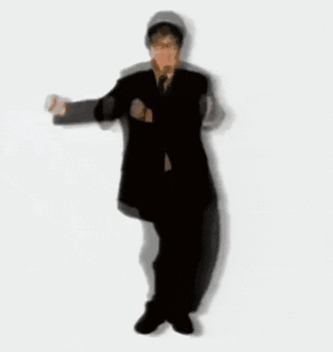 a man in a suit is dancing with his hands outstretched
