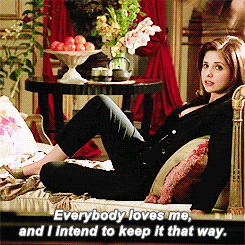 a woman is laying on a couch and says " everybody loves me "