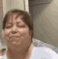 a close up of a woman 's face with her eyes closed and smiling .