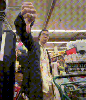a man giving a thumbs down in a store
