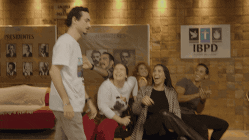 a group of people are laughing in front of a board that says ibpd