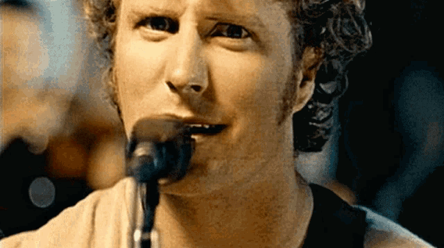 a man singing into a microphone with a beard