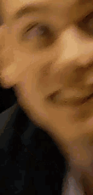 a close up of a man 's face with a blurred background