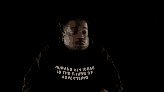 a man wearing a black sweatshirt that says humans with ideas is the future of advertising