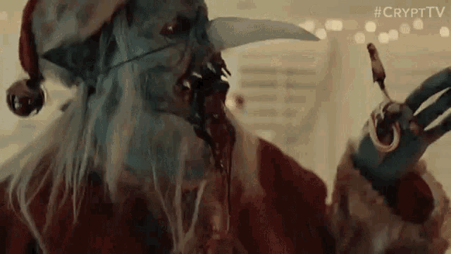 a close up of a demon dressed as santa claus holding a spoon in his hand .
