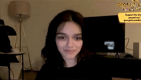 a woman is sitting in front of a television in a dark room .