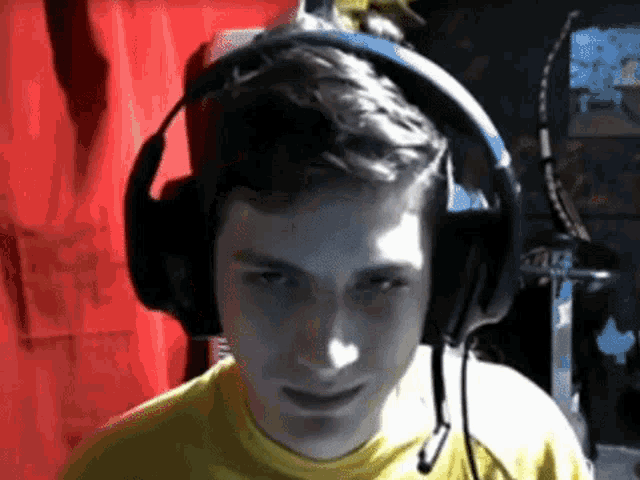 a man wearing headphones and a yellow shirt with the word atlas on it