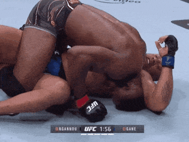 a fighter wearing a pair of ufc gloves is wrestling another man