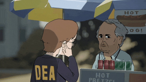 a man wearing a dea shirt talks to another man