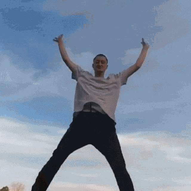 a man is jumping in the air with his arms in the air