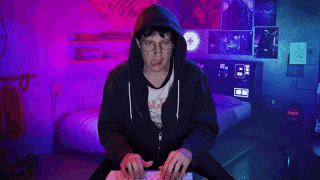 a man wearing a hoodie and glasses is playing a game