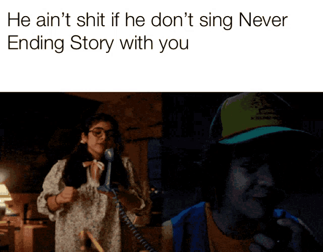 a girl talking on a telephone next to a man in a green hat with the words he ain 't shit