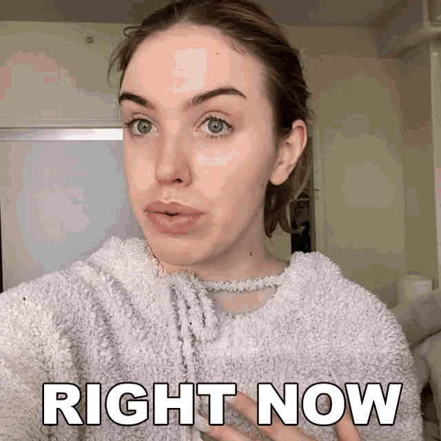 a woman wearing a sweater with the words right now on it