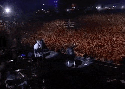a large crowd of people are gathered in a dark room .