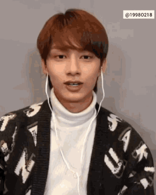 a young man wearing headphones and a sweater that says ' ua ' on it