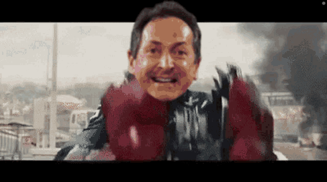 a man in a superhero costume with red gloves is smiling
