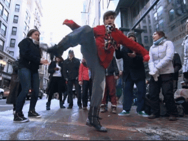a woman in a red jacket kicks her leg in the air in front of a crowd