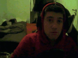 a young man wearing headphones and a red hoodie .