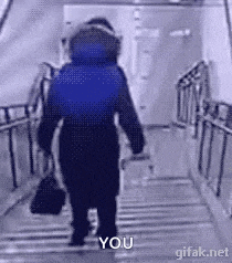 a person is walking down a set of stairs with a bag in their hand and says `` you '' .