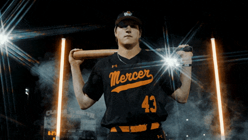 a baseball player wearing a mercer jersey is holding a bat over his shoulder