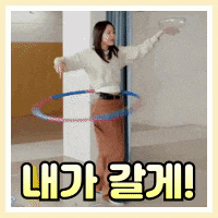 a woman is playing with a hula hoop in a room with korean writing .