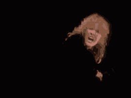 a close up of a person 's face in the dark with a black background .