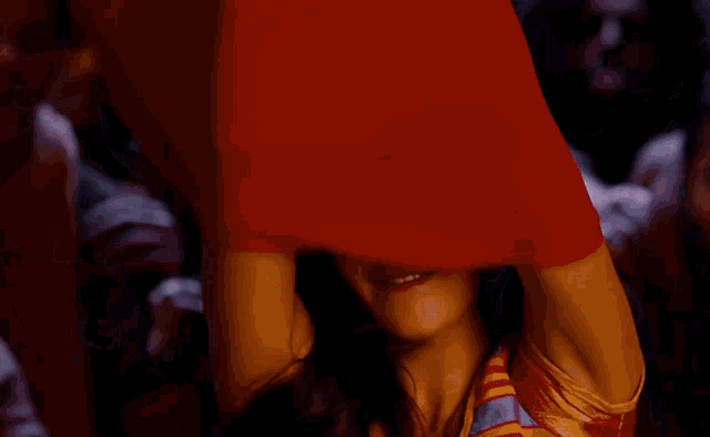 a woman adjusts her hair while a crowd watches